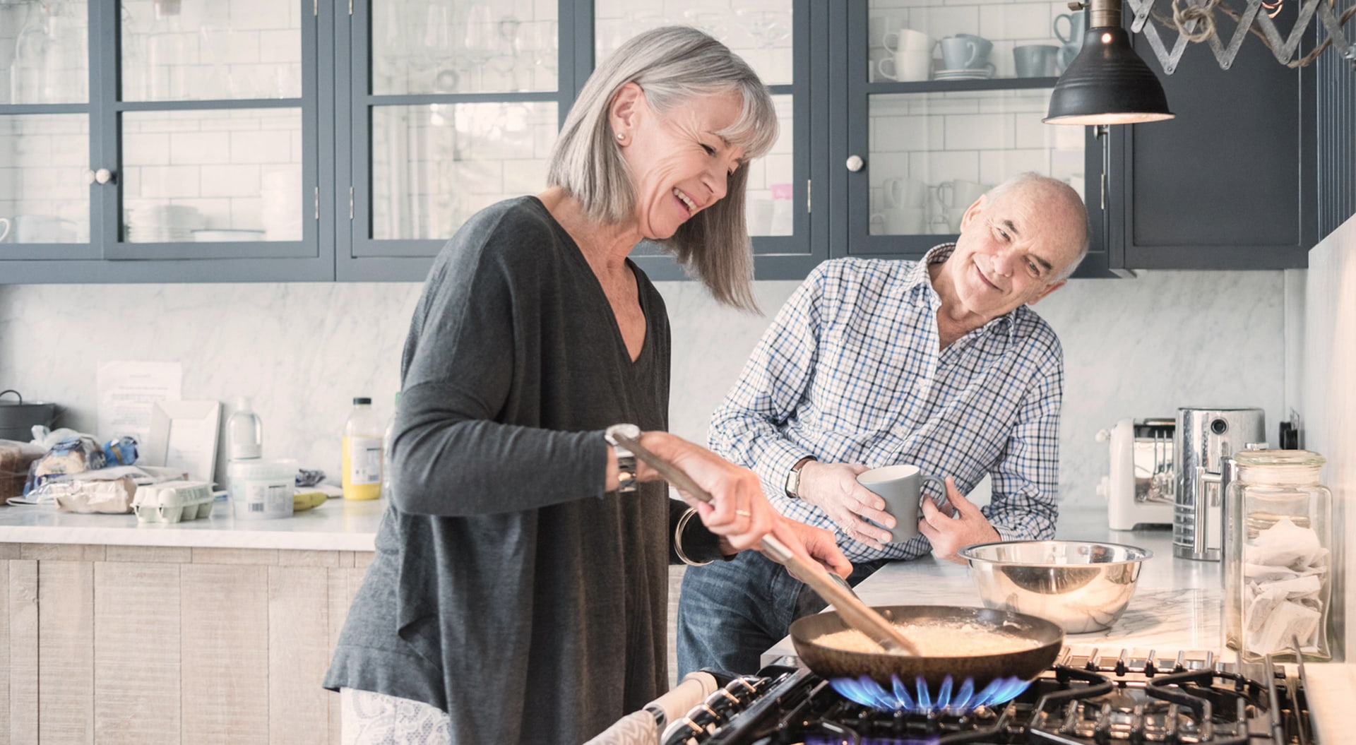 elderly couple cooking on a gas stove